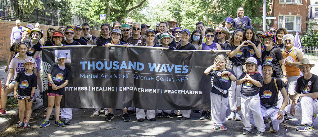 Thousand Waves members gathered behind banner preparing to march in the 2023 Chicago Pride Parade