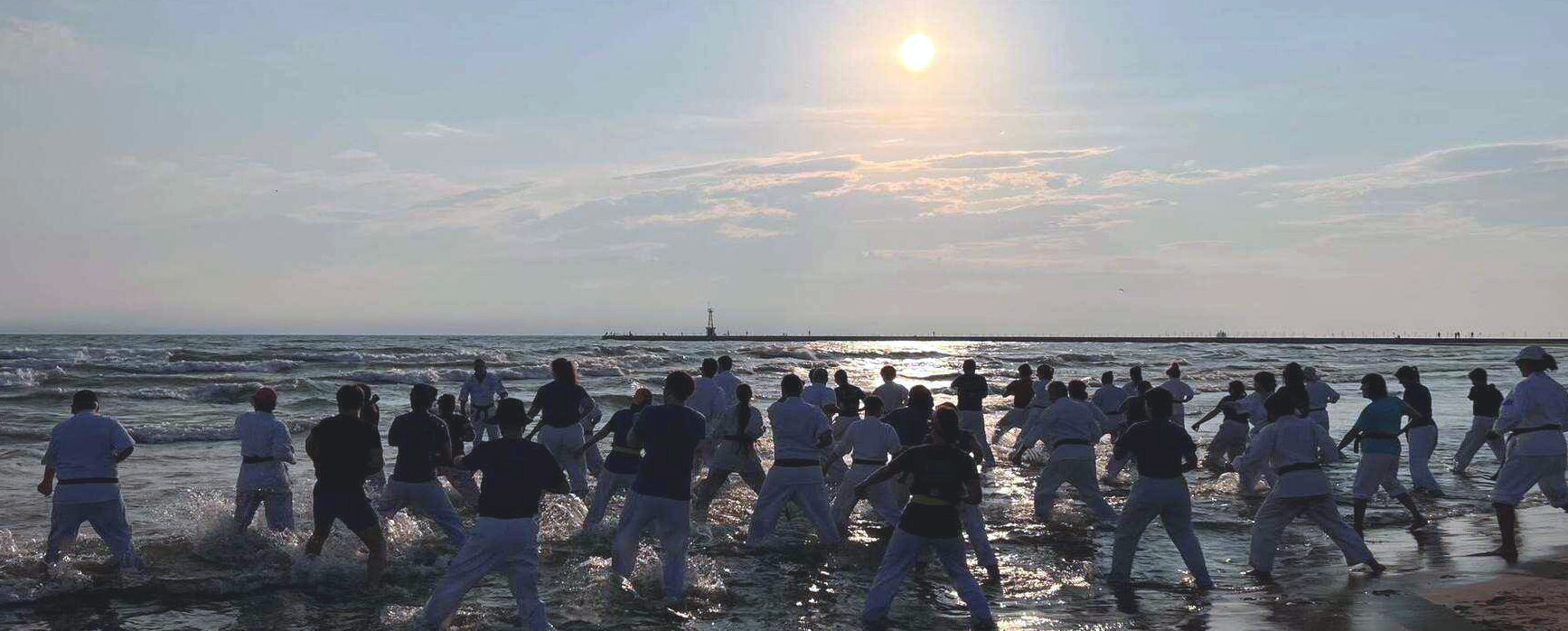 Beach Training 2025 Thousand Waves Students doing karate in Lake Michigan at dawn.